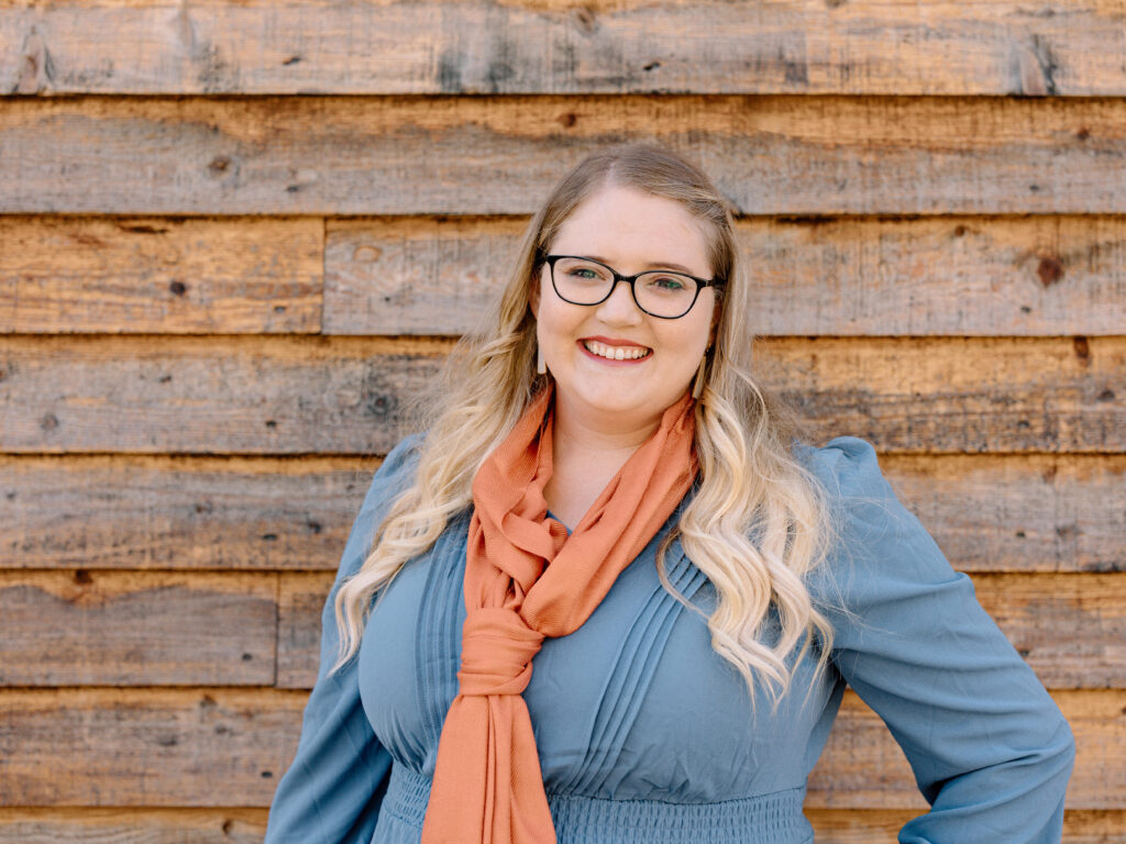 Kaelei Corbridge Posing for picture in front of a wood slat wall