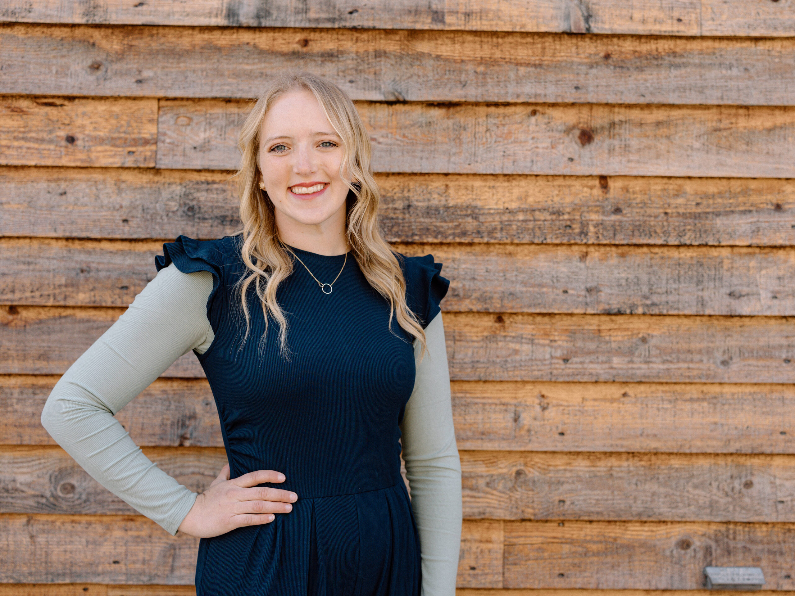 Brookelle Corbridge Posing for picture in front of a wood slat wall